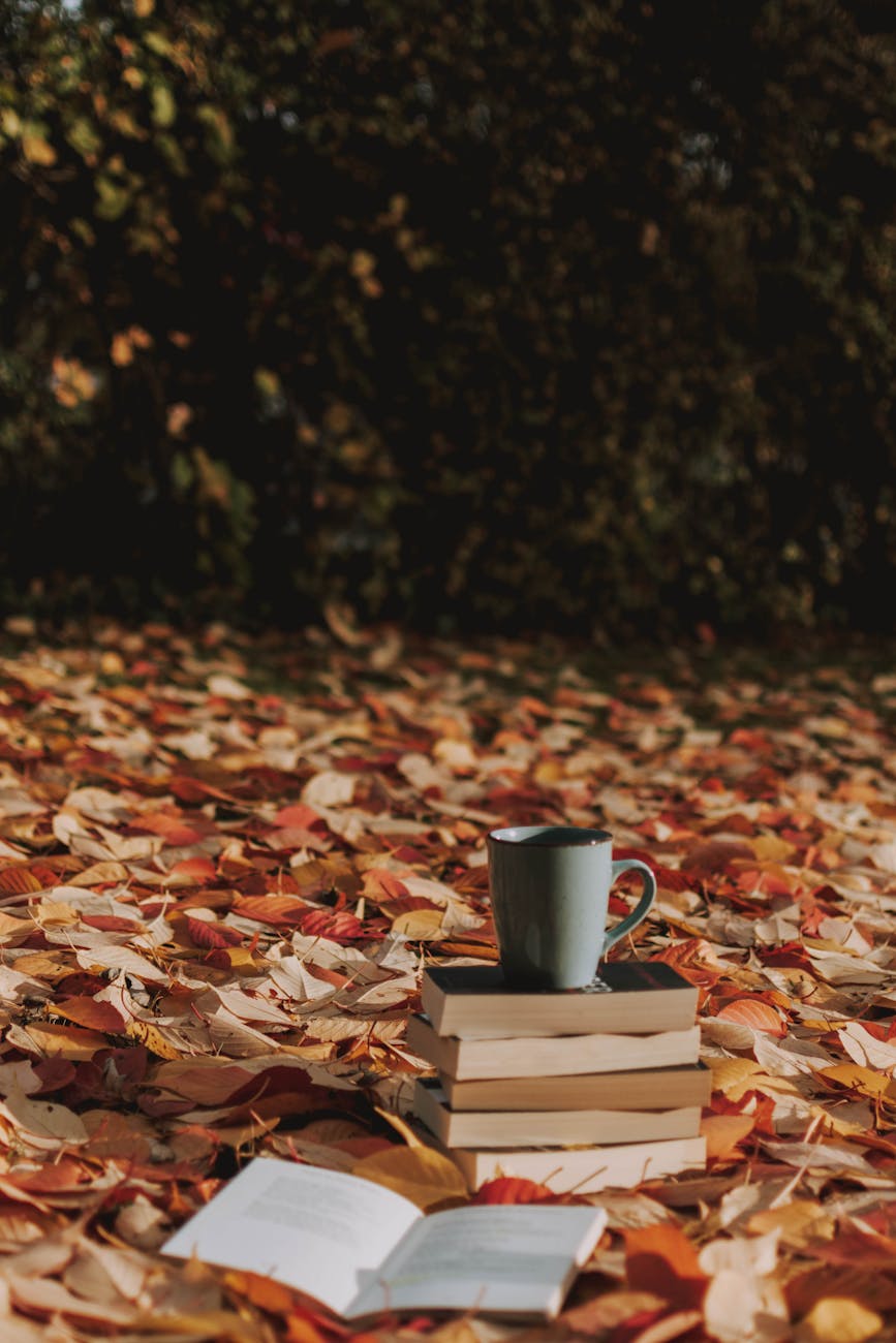 gray mug on top of piled books